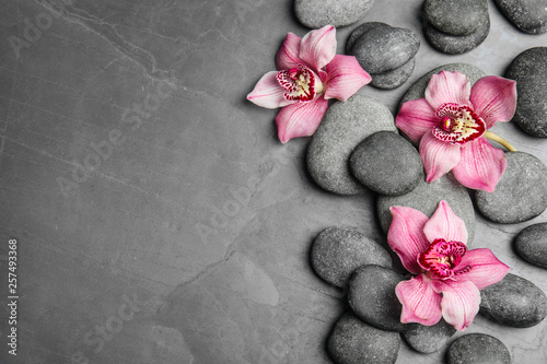 Obraz Kamienie Zen i egzotyczne kwiaty na ciemnym tle, widok z góry z miejscem na tekst