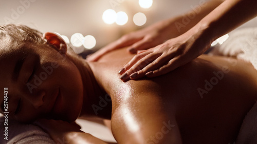 Girl receiving back massage in spa salon