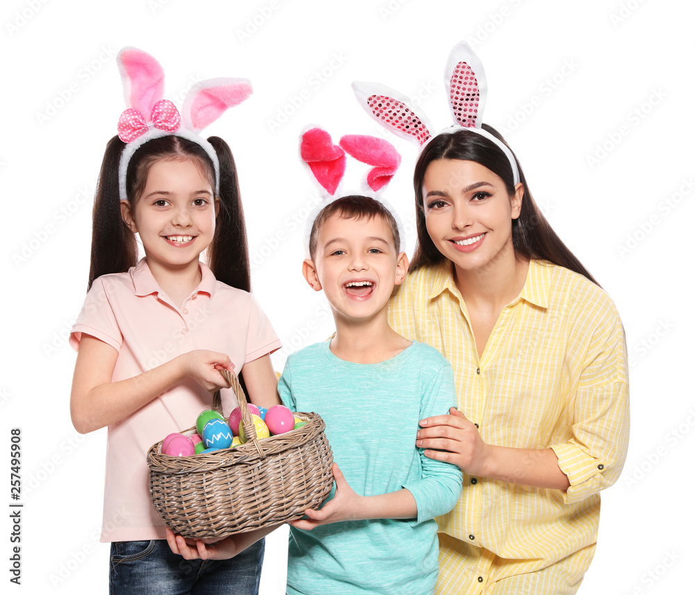 Cute family in bunny ears headbands with basket of Easter eggs on white background Cute family in bunny ears headbands with basket of Easter eggs on white background