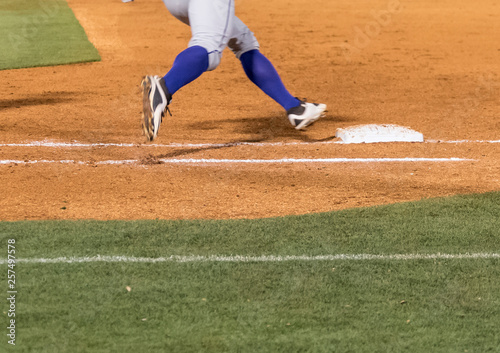 Low section of a baseball player rounding first base