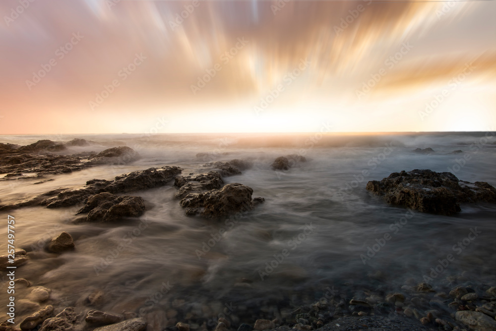 Fototapeta premium Sunset over the sea and beautiful long exposure clouds. Greece, Crete island.
