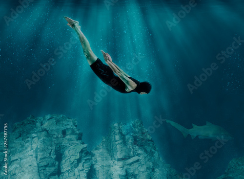 Professional swimmer underwater in abyss o