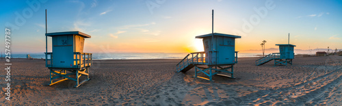 Deserted lifeguard stands on beach during sunset photo