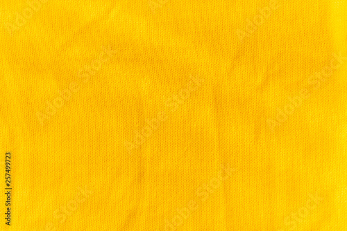Yellow crocheted fabric texture. Material is crumped a little
