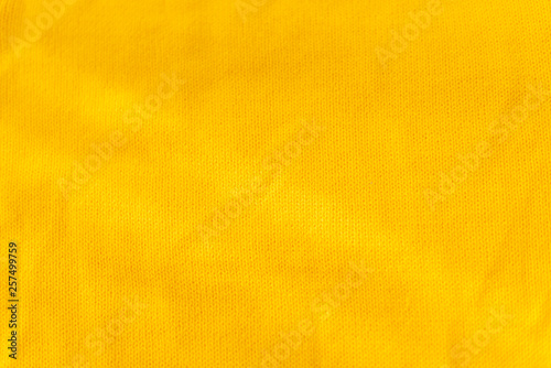 Yellow crocheted fabric texture. Material is crumped a little