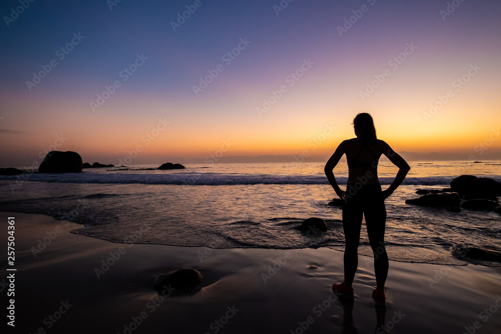 female athlete doing yoga on a beach