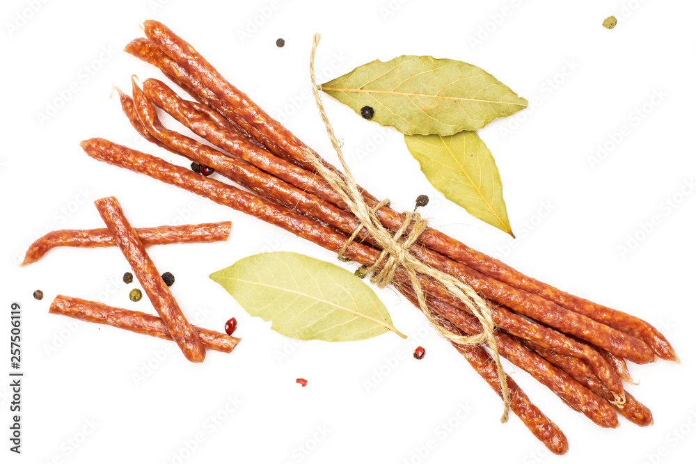 Fototapeta premium Group of lot of whole three pieces of spicy salami stick tyrolini tied by jute with bay leaf and black pepper flatlay isolated on white background
