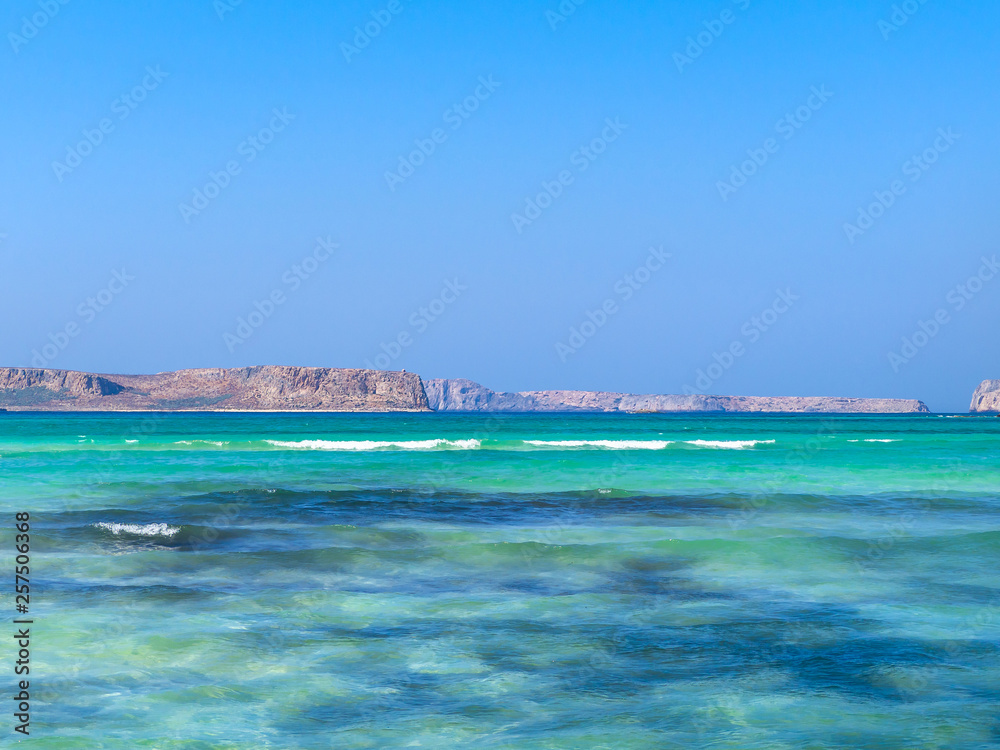 Fototapeta premium Brilliant azure blue water and rocky islands in the background