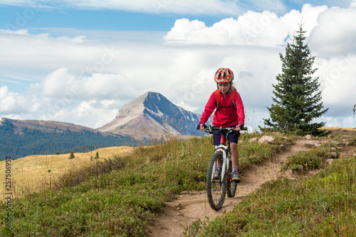 A young girl mountain biking in the San Juan National Forest, Silverton, Colorado.