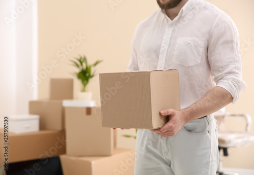 Man holding moving box in new office, closeup. Space for text © New Africa