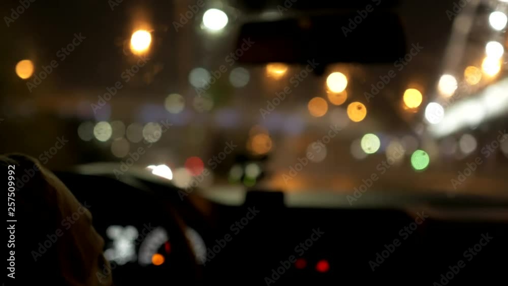 evening city through the windshield of the car, the driver with glasses. Video with defocus, beautiful bokeh of lights. car dashboard in shot evening city through the windshield of the car, the driver with glasses. Video with defocus, beautiful bokeh of lights. car dashboard in shot