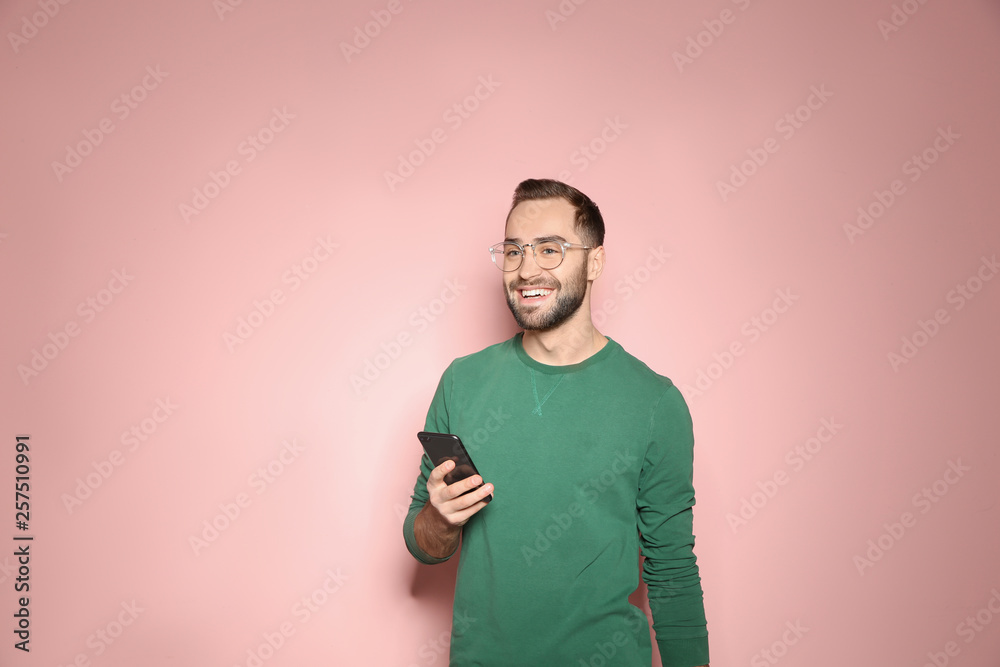 Handsome young man with mobile phone on color background Handsome young man with mobile phone on color background