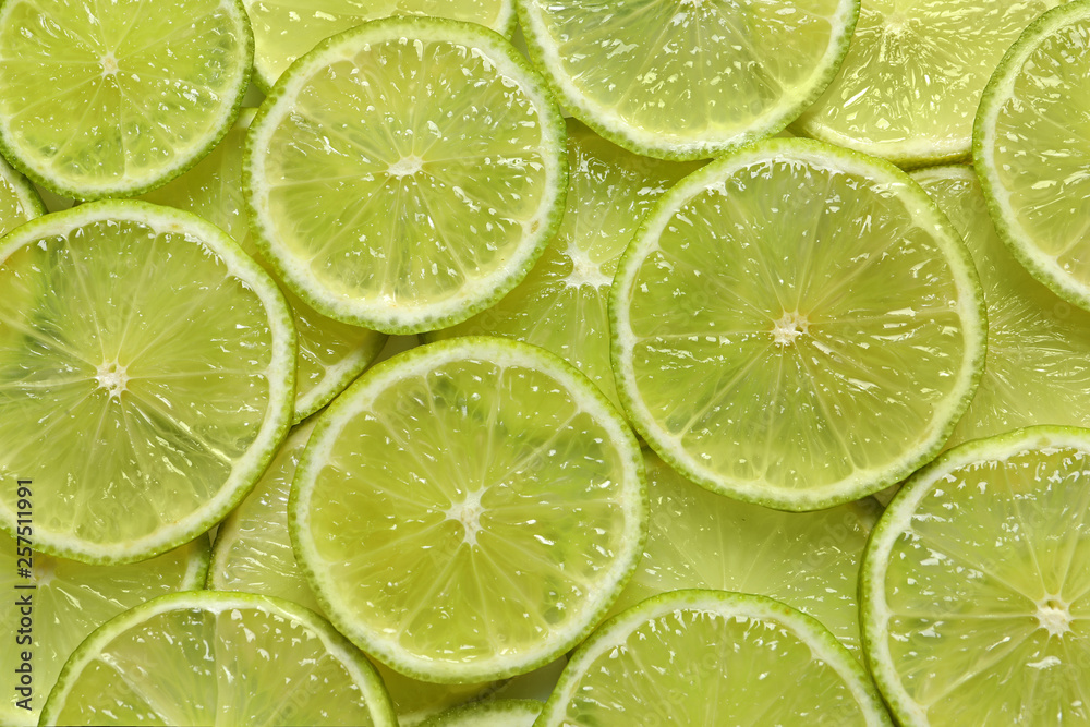 Juicy lime slices as background, top view. Citrus fruit