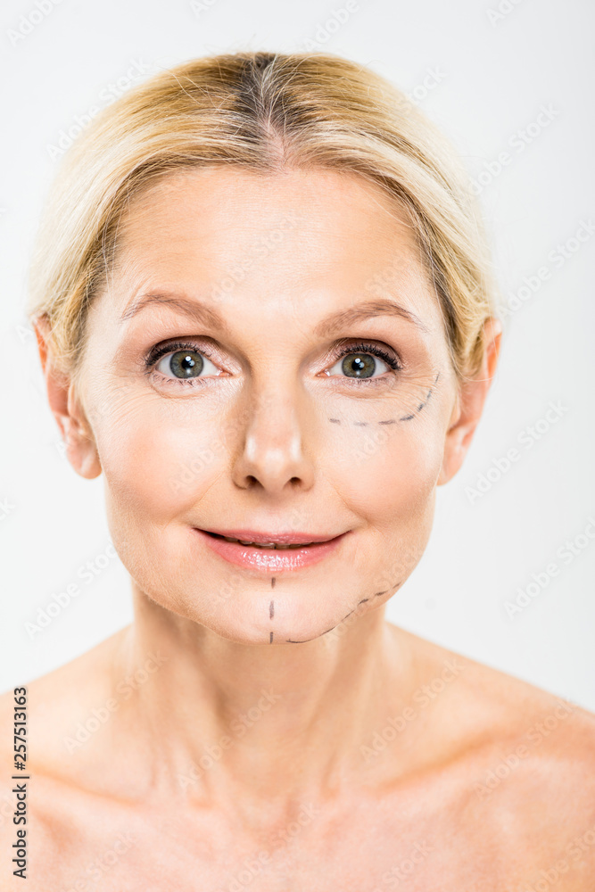beautiful and middle aged woman with lines on face looking at camera on grey background beautiful and middle aged woman with lines on face looking at camera on grey background
