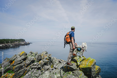 Man with dog hiking along Atlantic coast