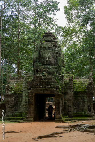 Tourists going through an ancient Angkor gate near Angkor Wat
