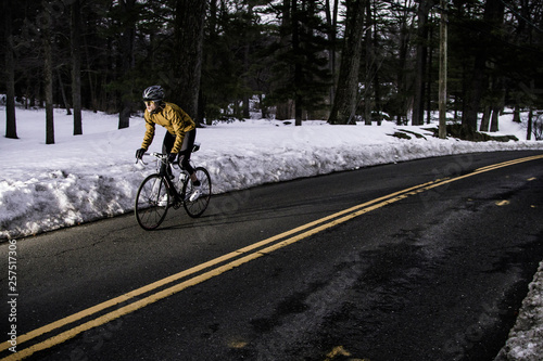 A road cyclist rides through a wintery landscape. photo