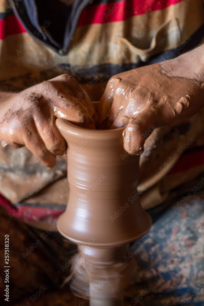 ceramic workshop - the man  makes a pot of clay on a potter's wheel