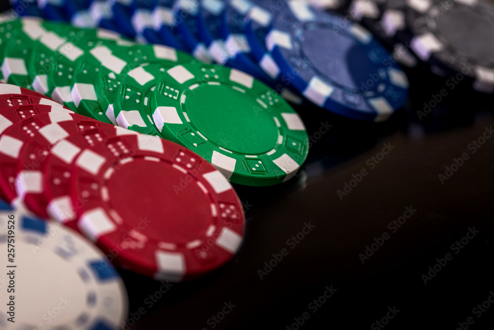 Selective focus on colorful casino chips on dark background Selective focus on colorful casino chips on dark background