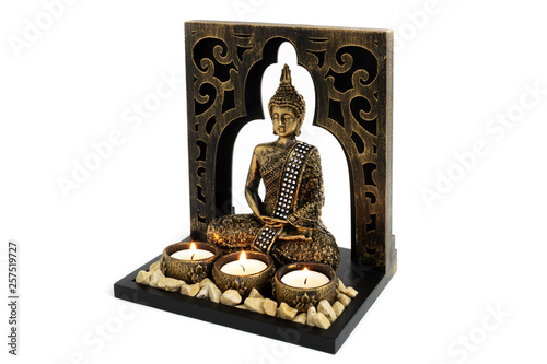 Foto Buddha sculpture with golden color in decorative frame with candles and stones a