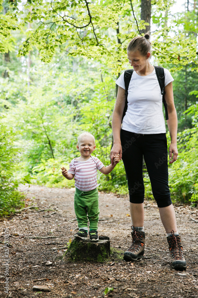 Devoted mother holding hands with her son, walking in the woods. Devoted mother holding hands with her son, walking in the woods.