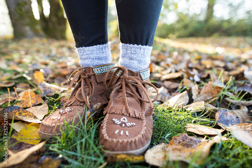 Moccasin shoes on legs of woman in park photo