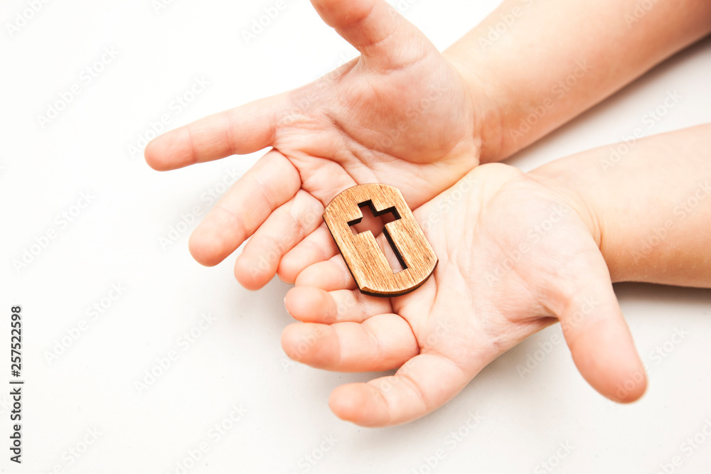 A little wooden cross in the child's hands