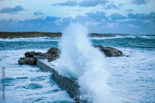 Wave crashing against breakwater in sea