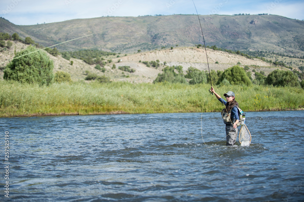 Woman fishing in river, Colorado, USA Woman fishing in river, Colorado, USA