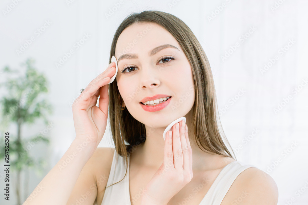 Home face care. Perfect Fresh Skin. Beautiful Face of Young Woman removing makeup. Woman hand with cotton pad. Skin clean with cotton. Skin Care Concept Home face care. Perfect Fresh Skin. Beautiful Face of Young Woman removing makeup. Woman hand with cotton pad. Skin clean with cotton. Skin Care Concept