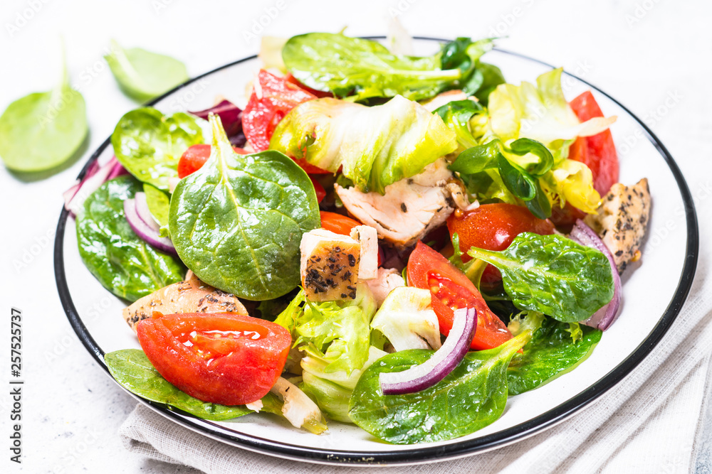 Green salad with chicken and vegetables on white. Green salad with chicken and vegetables on white.