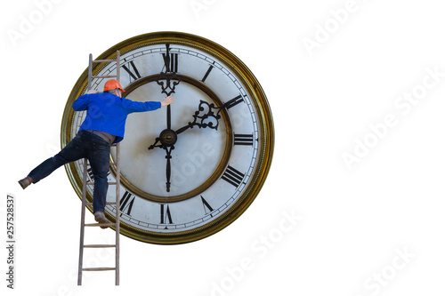 Man is standing on a ladder and adjusting the clock photo