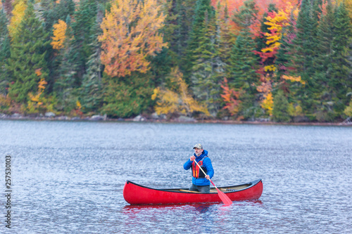 A man canoeing on Greenough Pond in Wentworths Location, New Hampshire. Fall. Northern Forest. photo