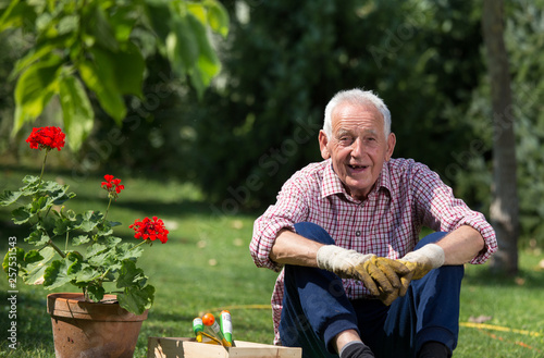 Old man with flower pot and gardening equipment