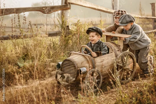 Obraz Dzieci jeżdżą na prowizorycznym drewnianym samochodzie wyścigowym