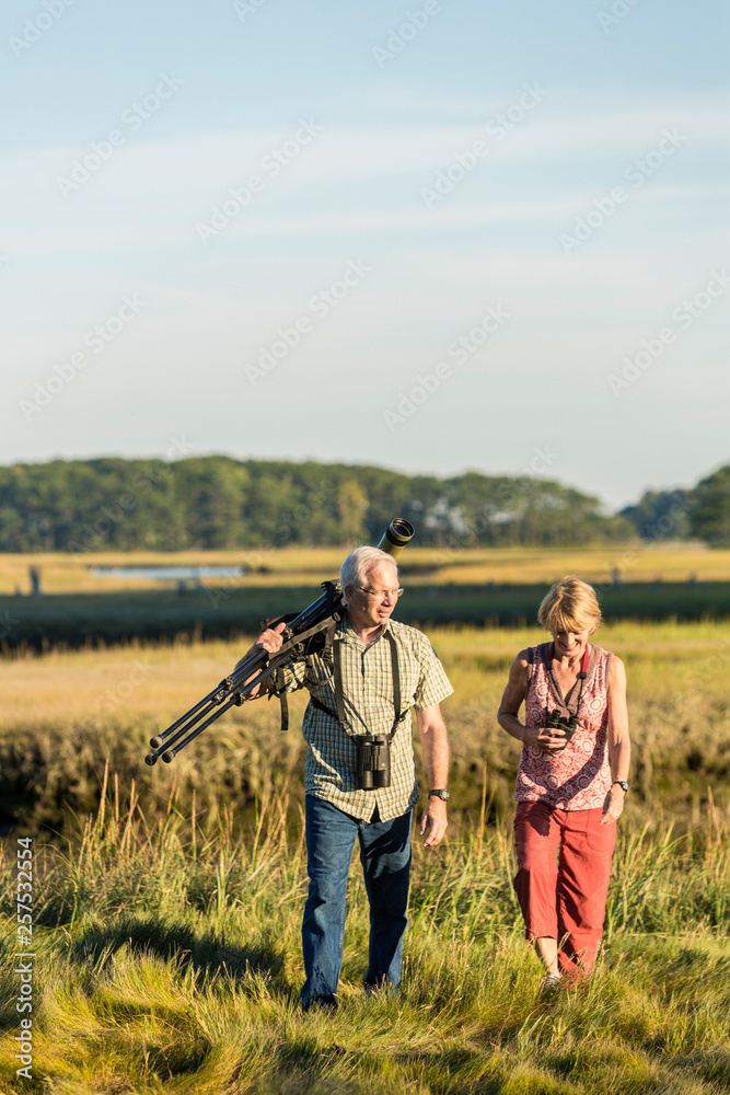 A couple bird watching on a salt marsh at the Brave Boat Harbor Headwaters preserve in Kittery, Maine. A couple bird watching on a salt marsh at the Brave Boat Harbor Headwaters preserve in Kittery, Maine.