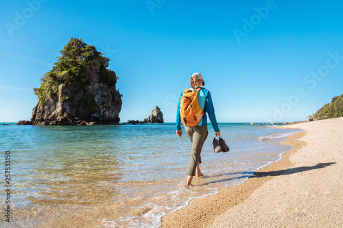 Woman walking along beach at Abel Tasman National Park photo