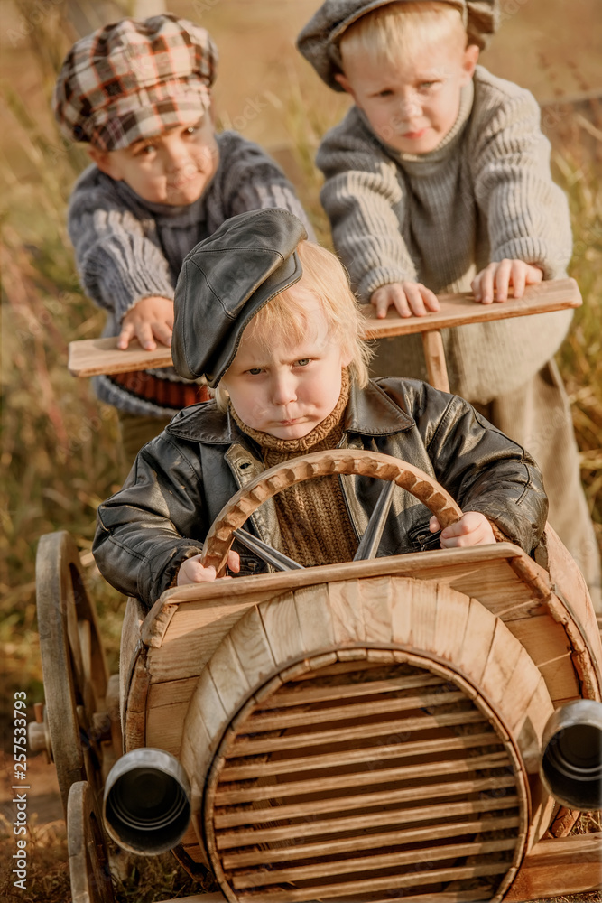Children ride on a makeshift wooden racing car