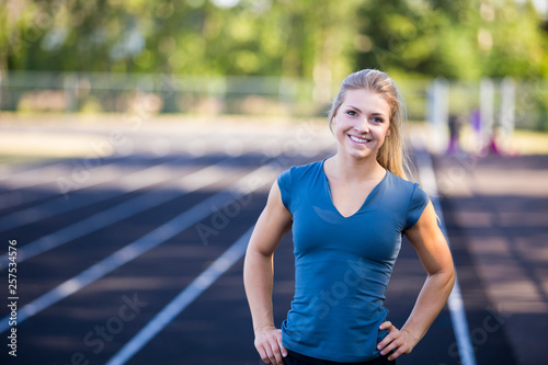 Portrait of smiling female runner standing on running track, Eugene, Oregon, USA photo