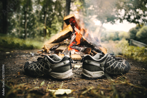 Hiking shoes drying beside campfire photo