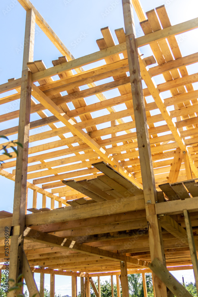 wooden interior frame of a new house under building, architectural residential construction stick built home framework. wooden interior frame of a new house under building, architectural residential construction stick built home framework.