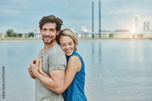 Happy young couple hugging at the riverbank