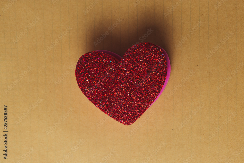 Top view of a red heart shape over a vintage paper Top view of a red heart shape over a vintage paper