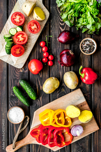 cooking with raw vegetables on dark wooden background top view