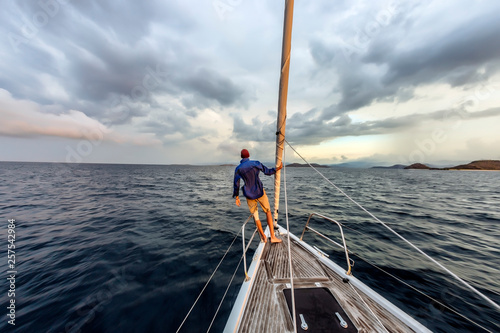 Man standing on bow of yacht, Lombok, Indonesia photo