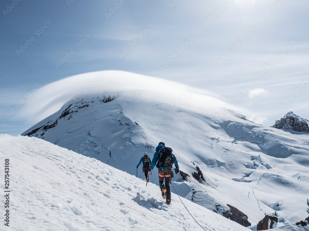 Climbers approaching summit on snow covered mountain Climbers approaching summit on snow covered mountain