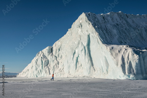 A man walks near a large iceberg in McMurdo Sound in the Southern Ross Sea. photo