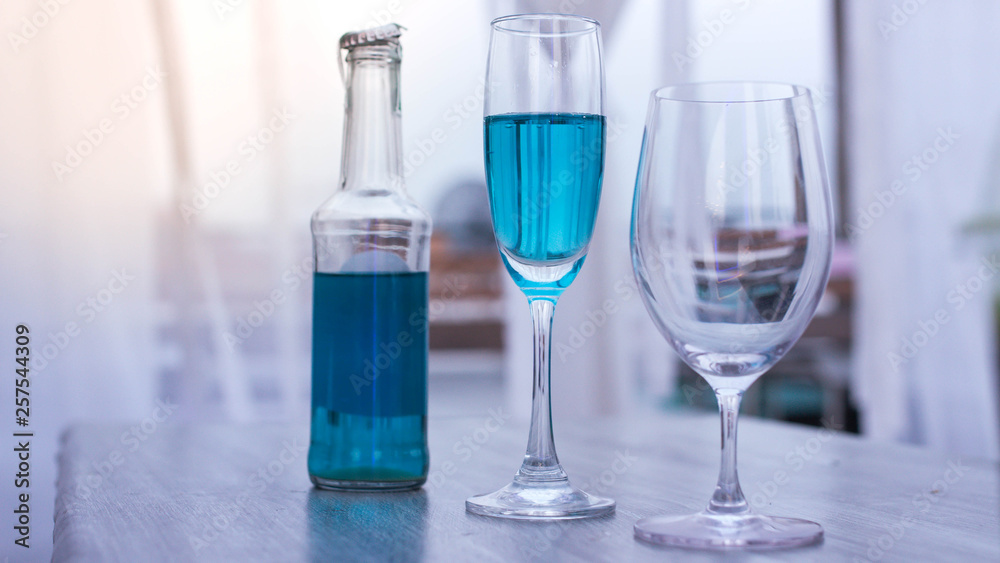 Wine Glasses and Blue Wine with Glasses of Champagne on table at restaurant Over sun background. Wine Glasses and Blue Wine with Glasses of Champagne on table at restaurant Over sun background.
