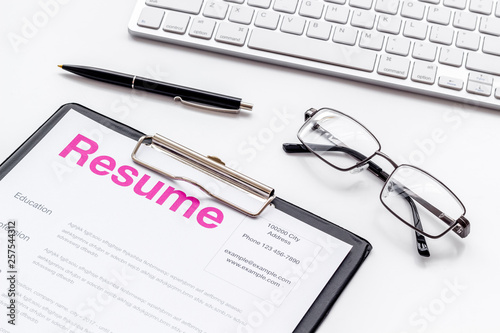 Create CV concept with pen, glasses, keyboard on white desk top view
