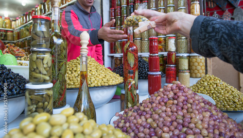 Customer buying olives at market, Marrakesh, Morocco